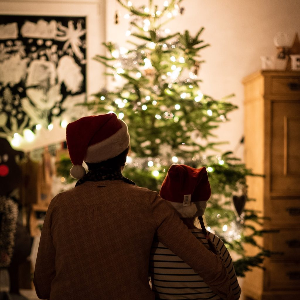 Parent with child looking at a Christmas tree