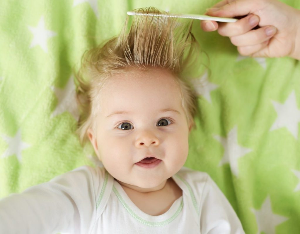 Baby getting hair combed.