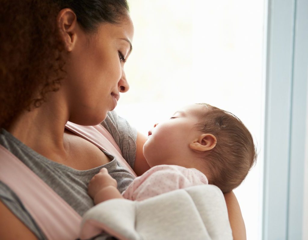 Mother holding sleeping baby.