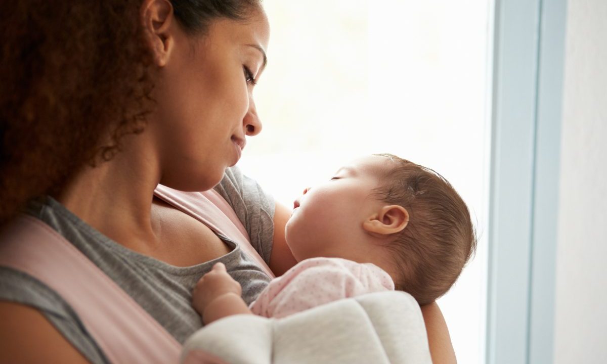 Mother holding sleeping baby.