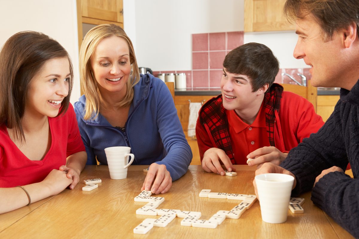 Family playing board game in kitchen