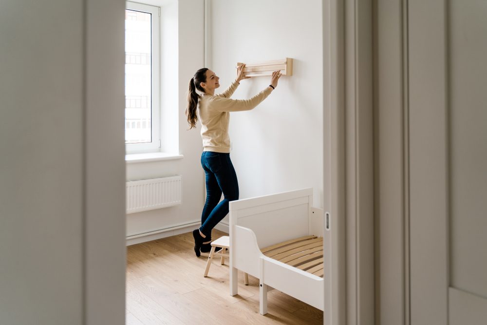 woman hanging shelf