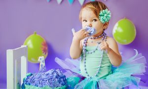 Baby girl enjoying her smash cake on her first birthday