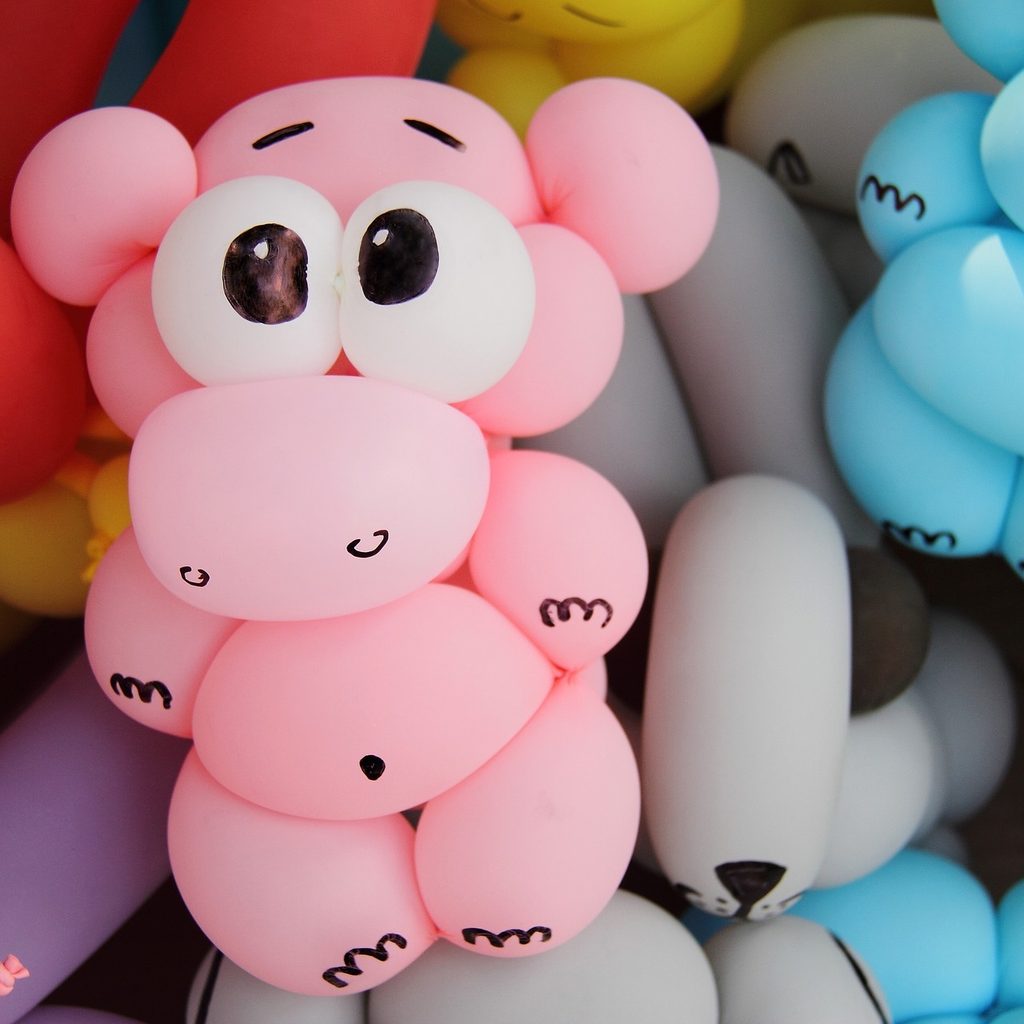 Balloon animals with drawn faces and googly eyes