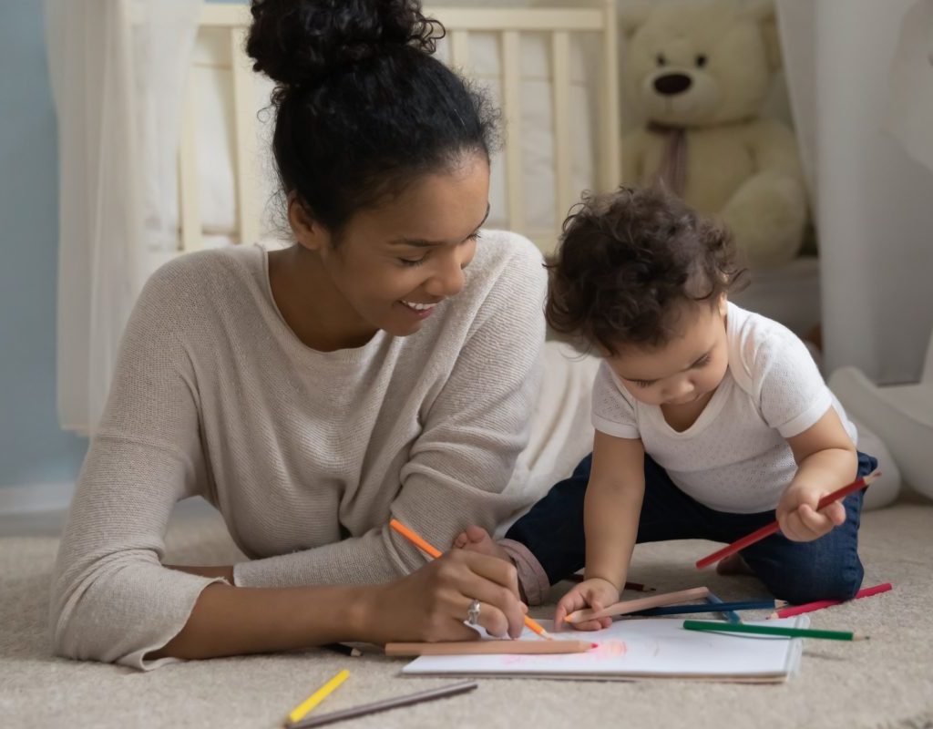 Mother and son coloring and playing on the floor