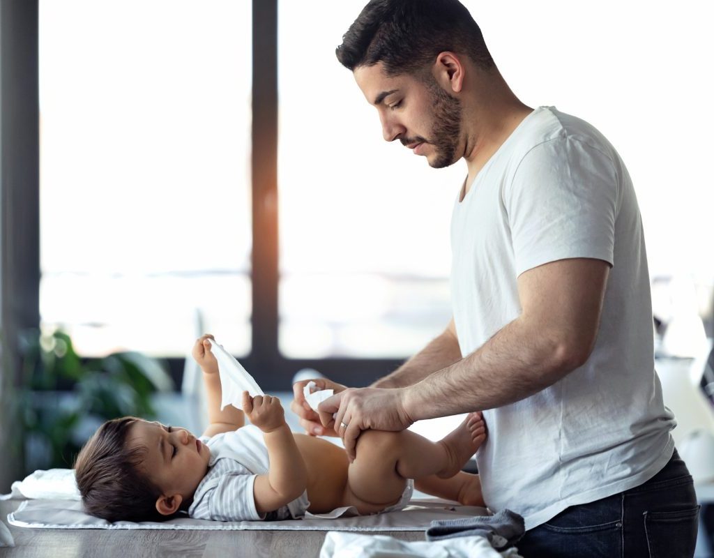 Dad changing son's diaper