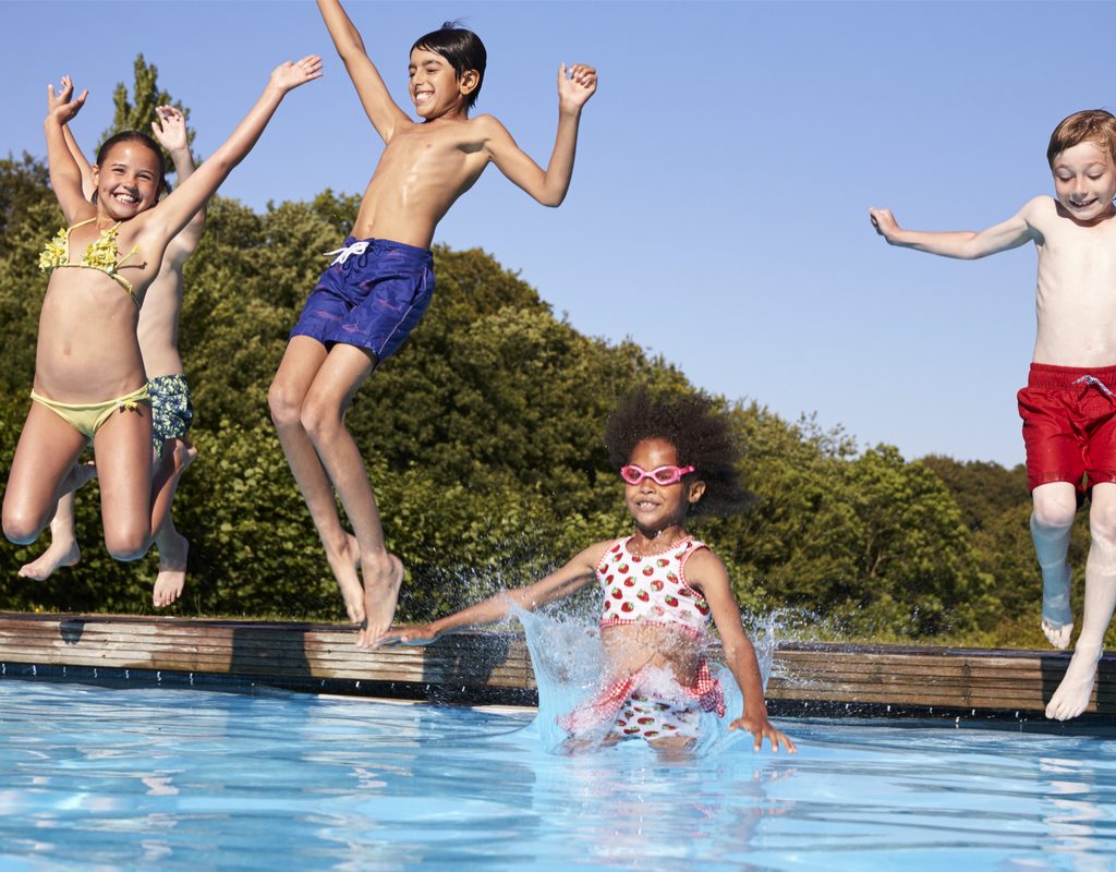 Kids jumping into a pool.