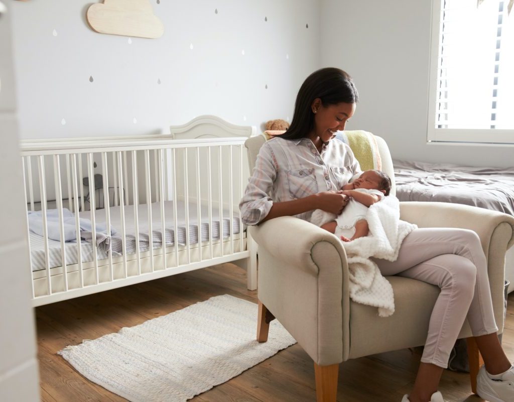 Mother holding a baby in a nursery.