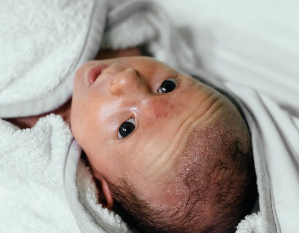 A newborn is swaddled in a towel