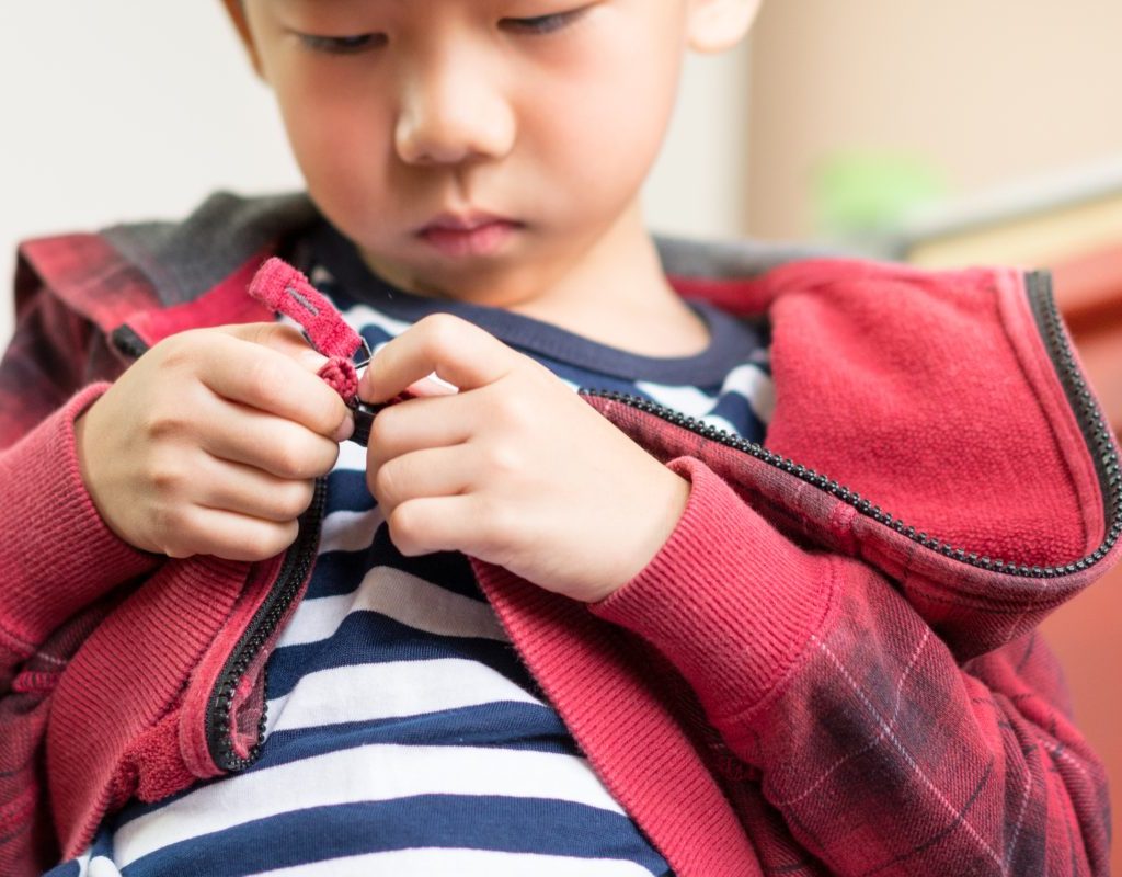 Child playing with his jacket zipper.