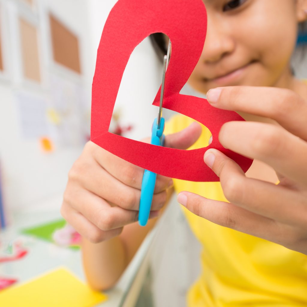 Child cutting a paper heart