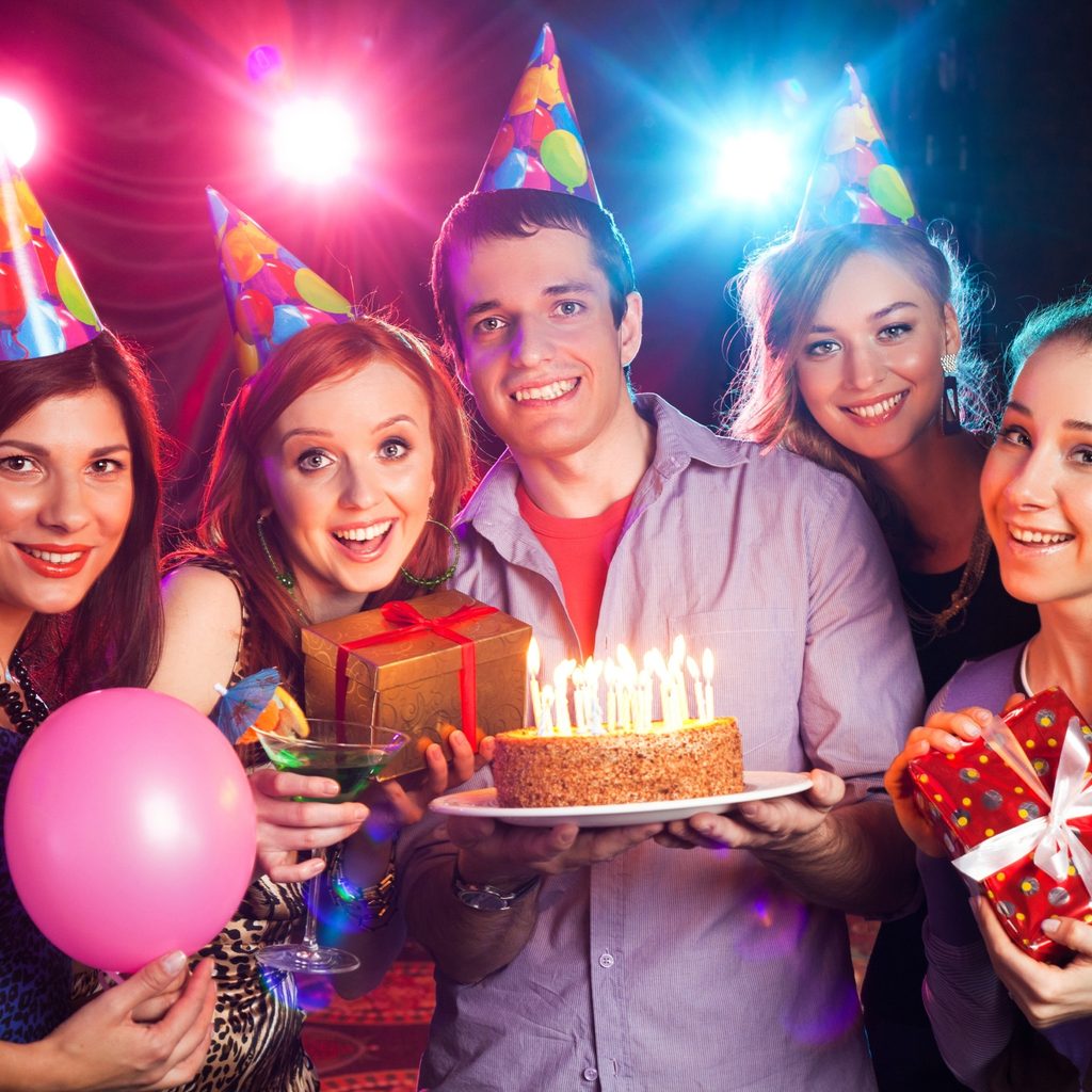 Group of teens in party hats having fun at a birthday party