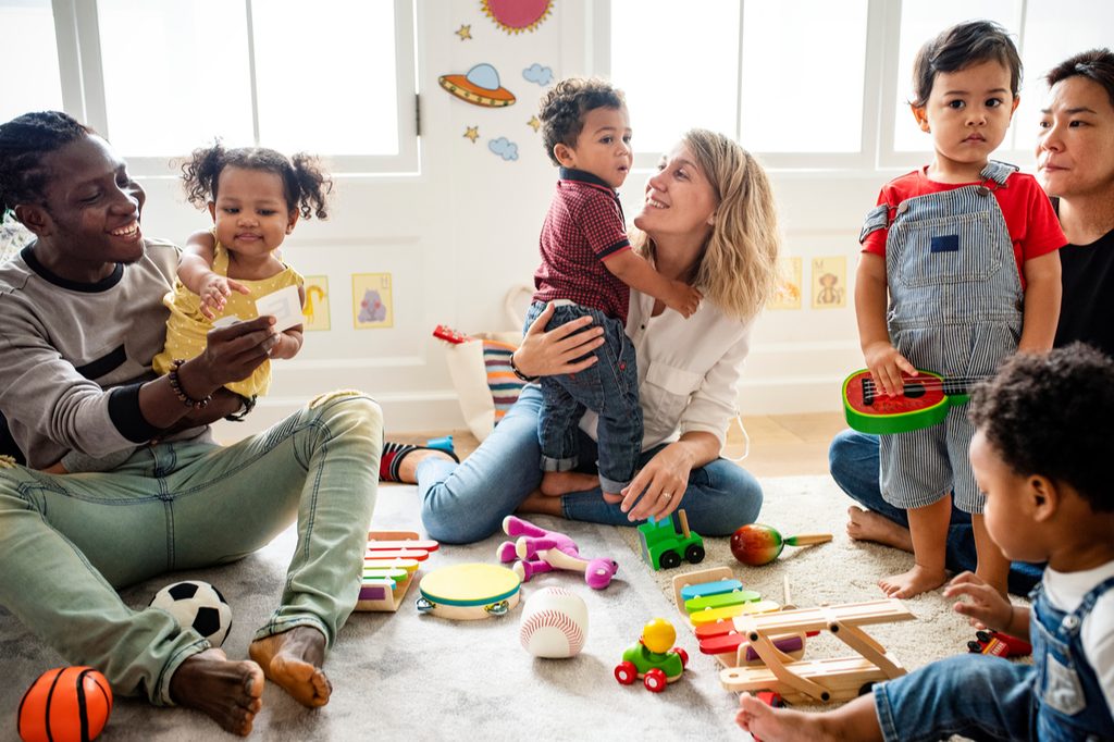 Toddlers having fun in a playgroup with parents.