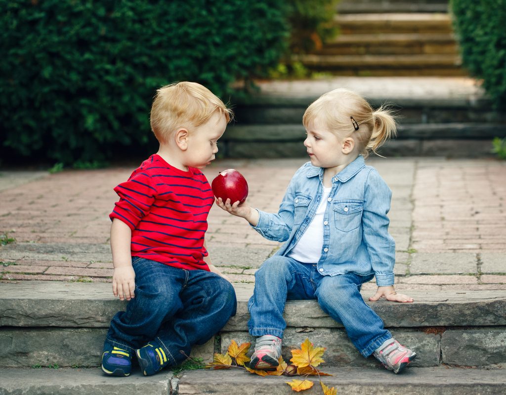 Toddlers share an apple