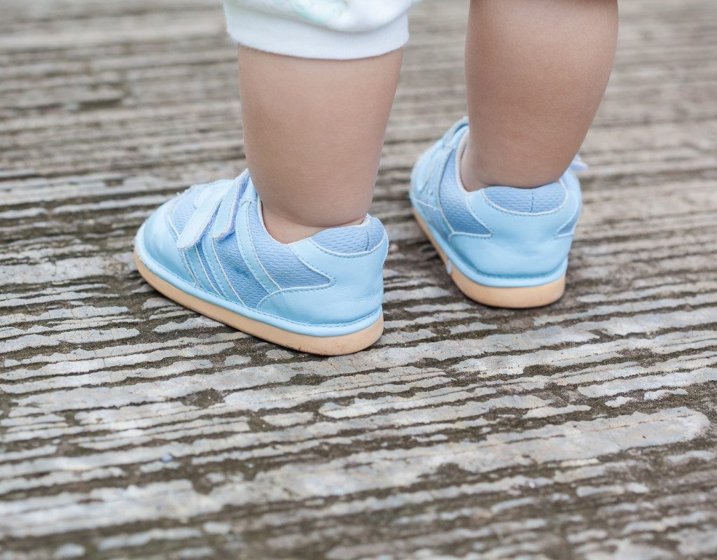 Child wearing baby shoes outside