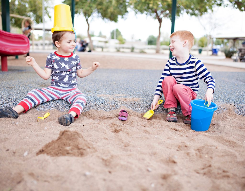 Two kids playing in sandbox