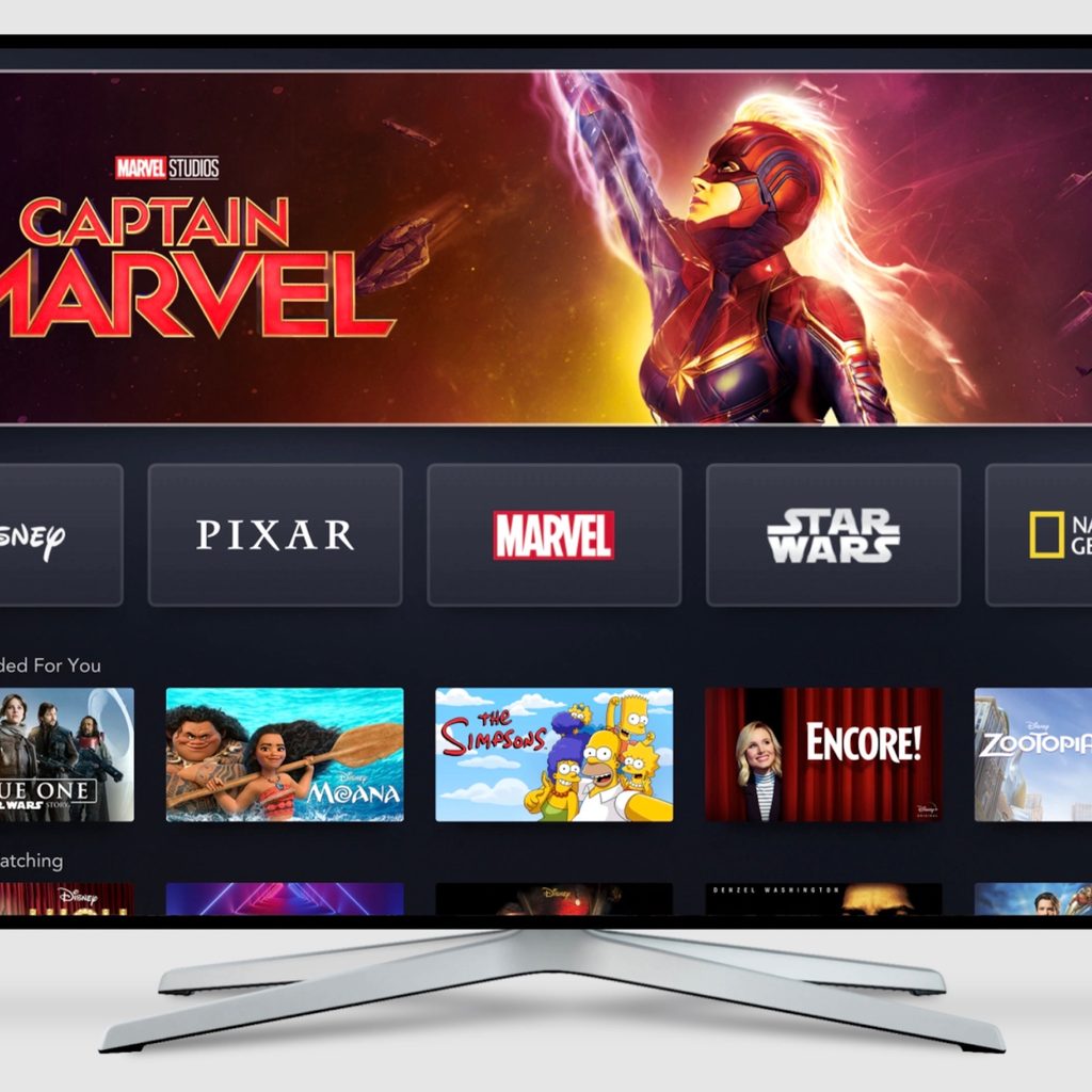 a large TV screen shows the homepage to Disney+