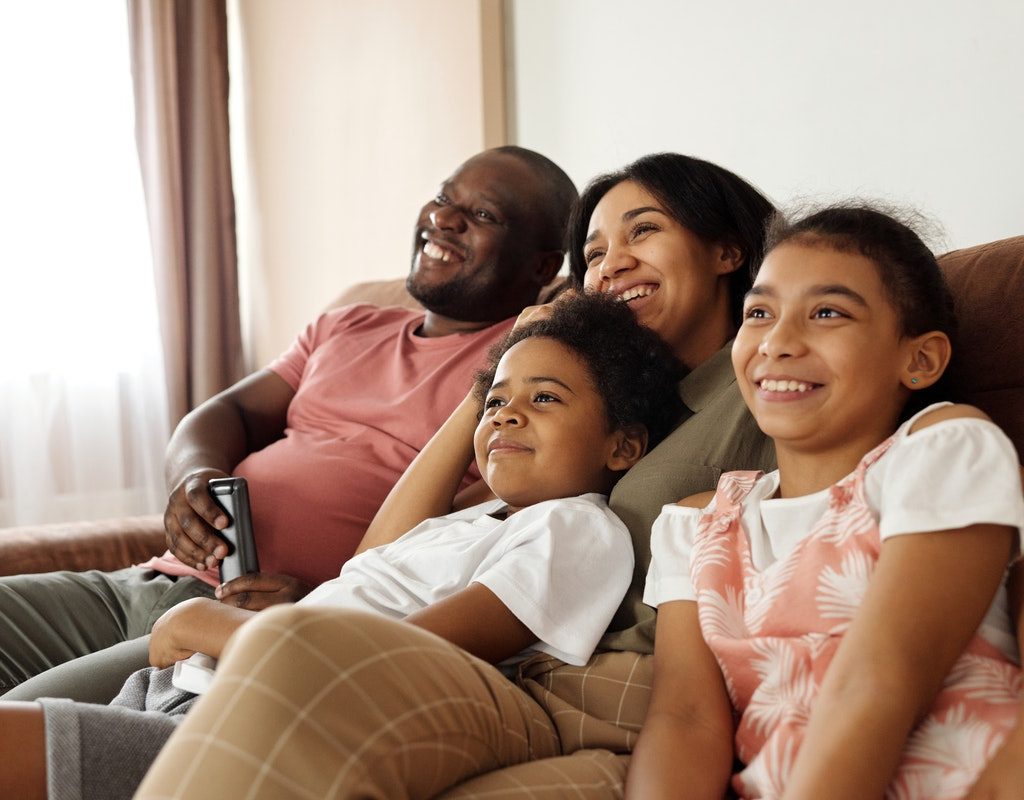 A family enjoying a movie on their couch