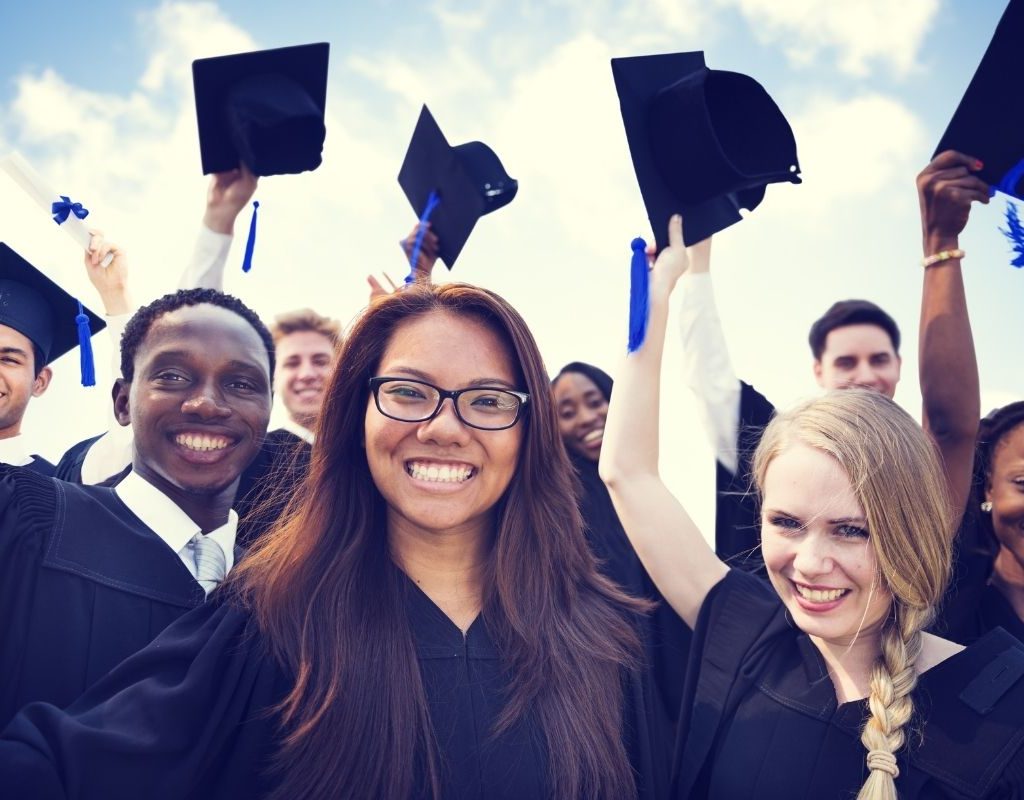 Teens celebrating in graduation robes