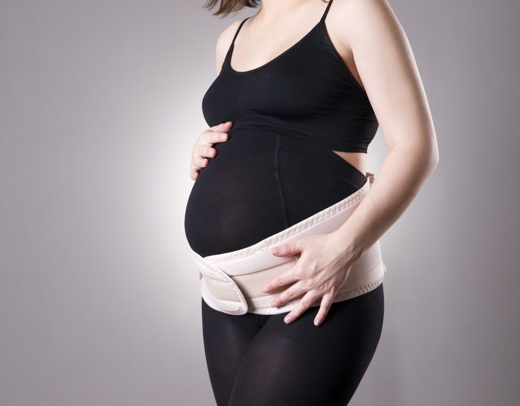 Standing pregnant woman in belly band