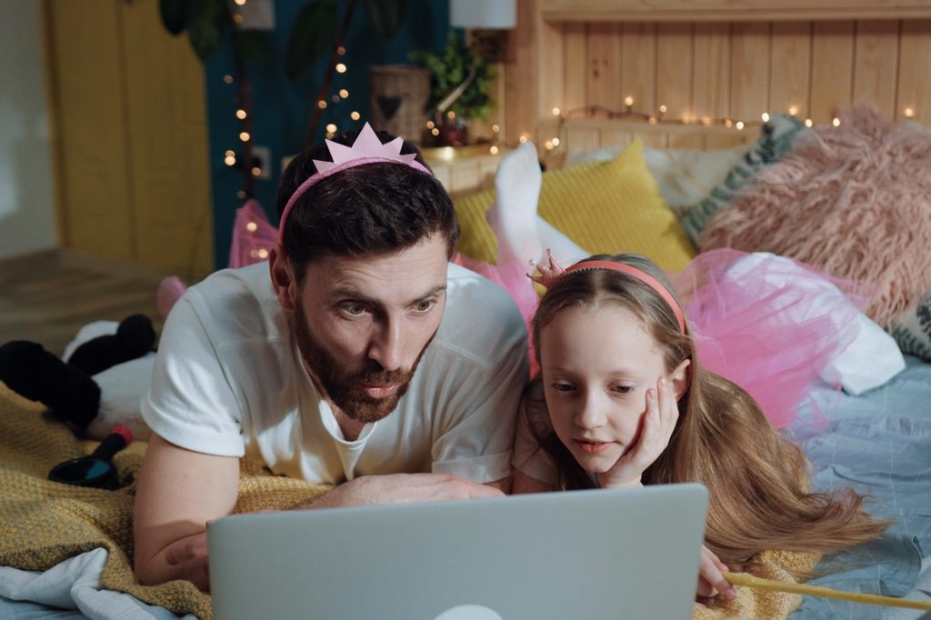 Dad and daughter watching a streaming show