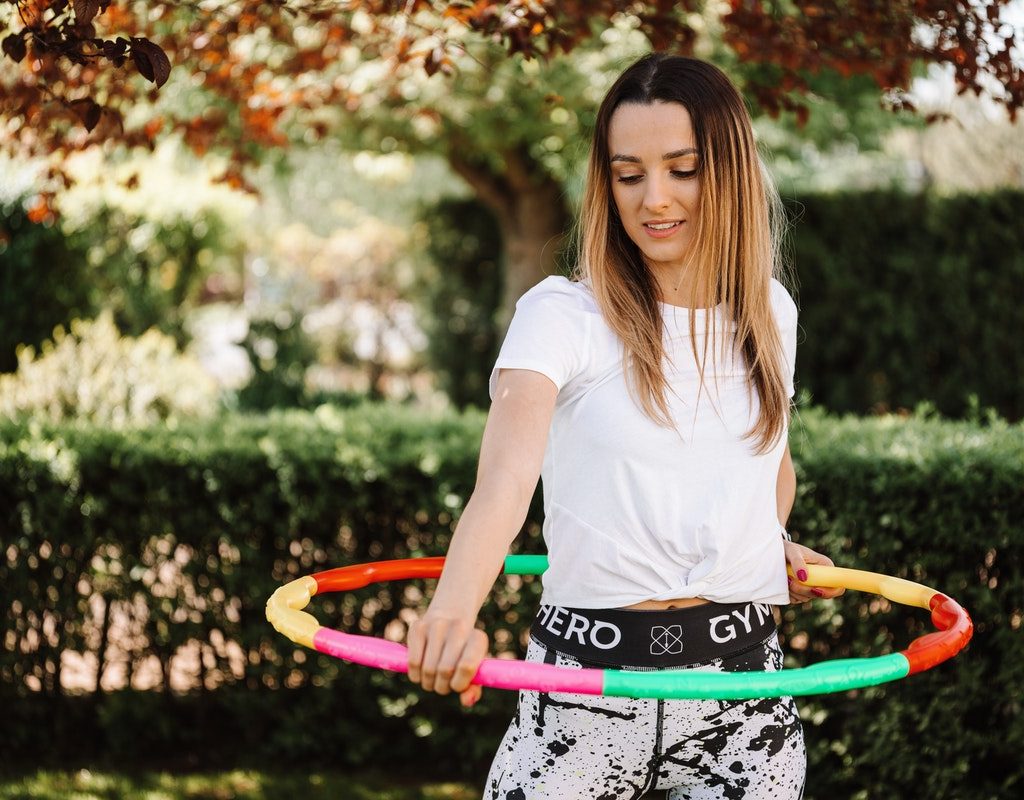 A teenager playing with a hula hoop