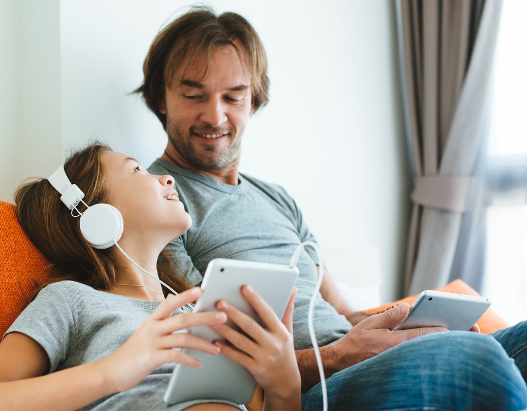 Father watching his daughter use her device online