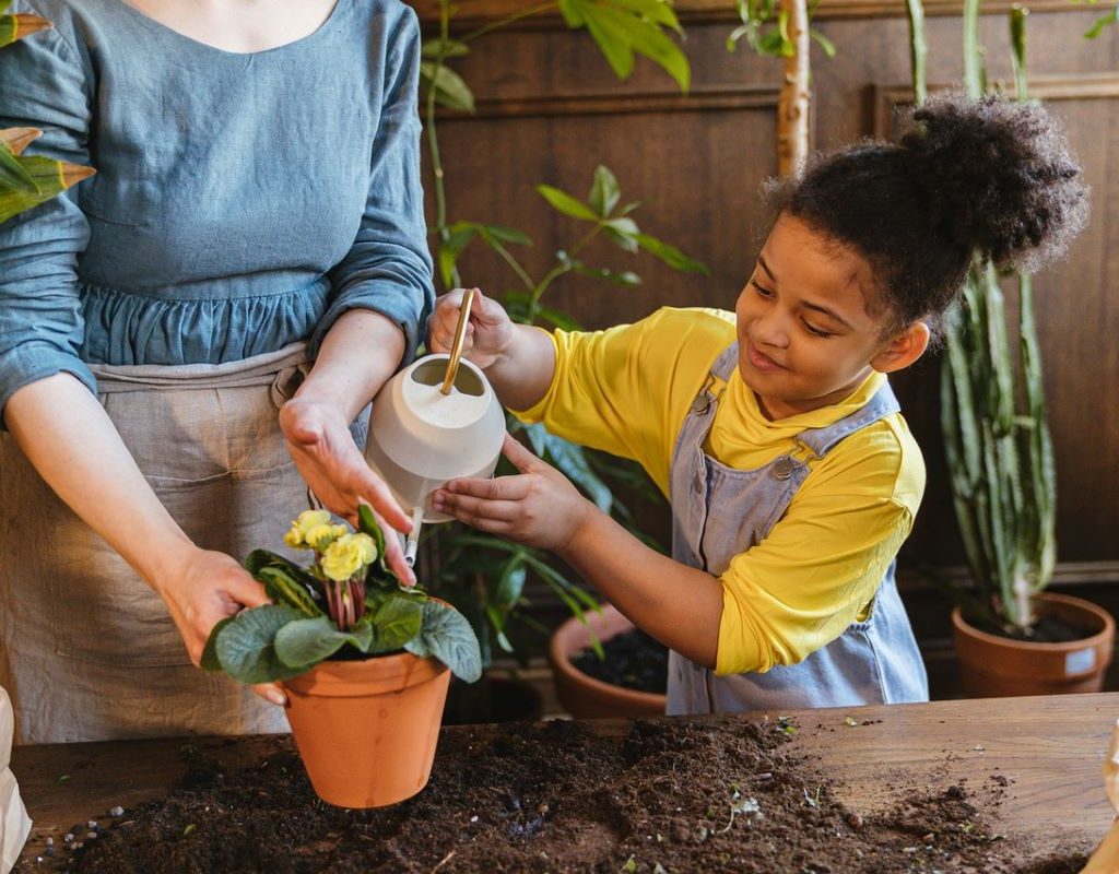 Mom and daughter watering plants