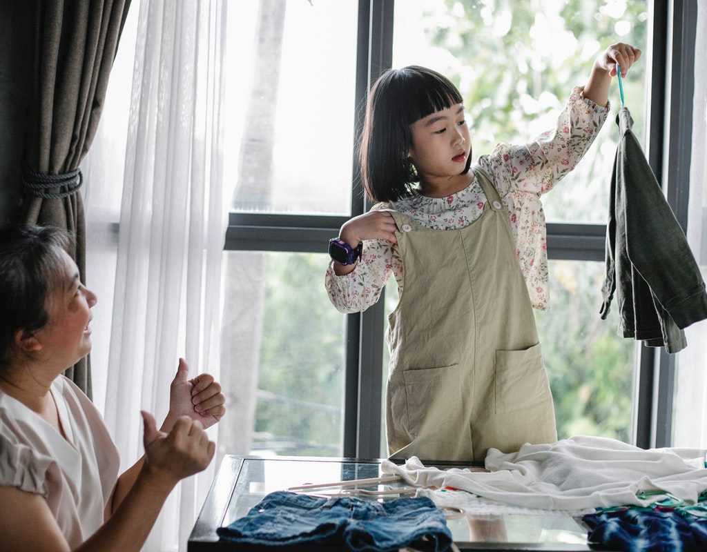 Little girl hanging up clothes for her grandmother