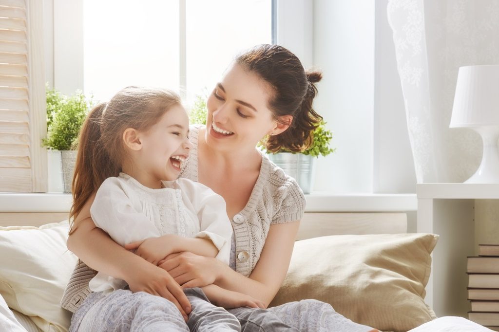 Mother laughing with her young daughter.