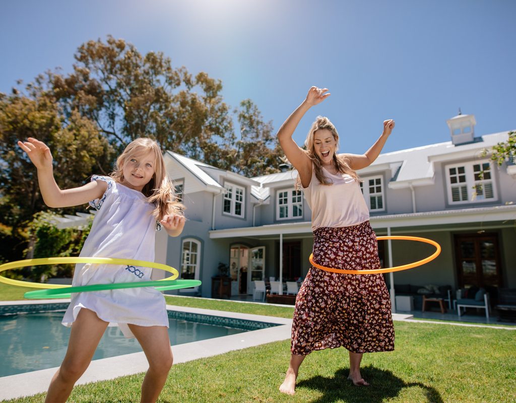 A mom and daughter having fun with hula hoops