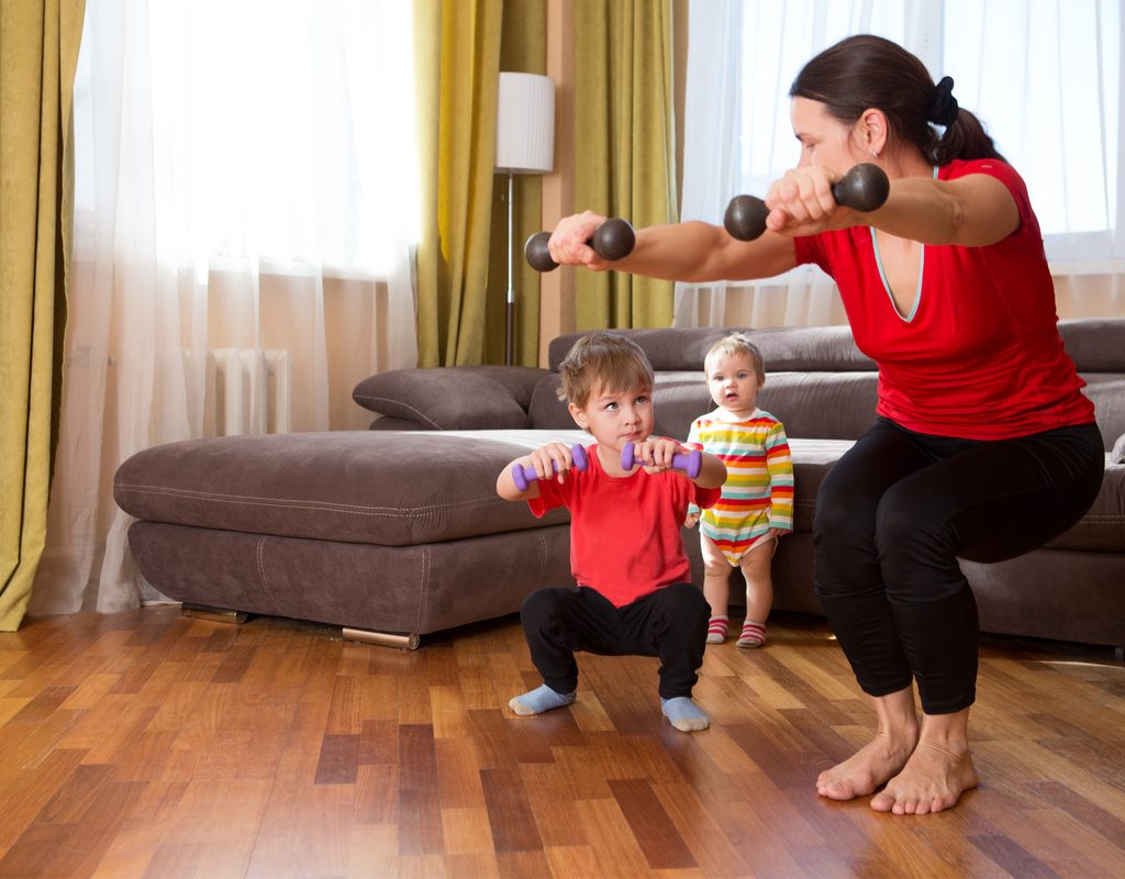 Mom working out with her todlers joining in