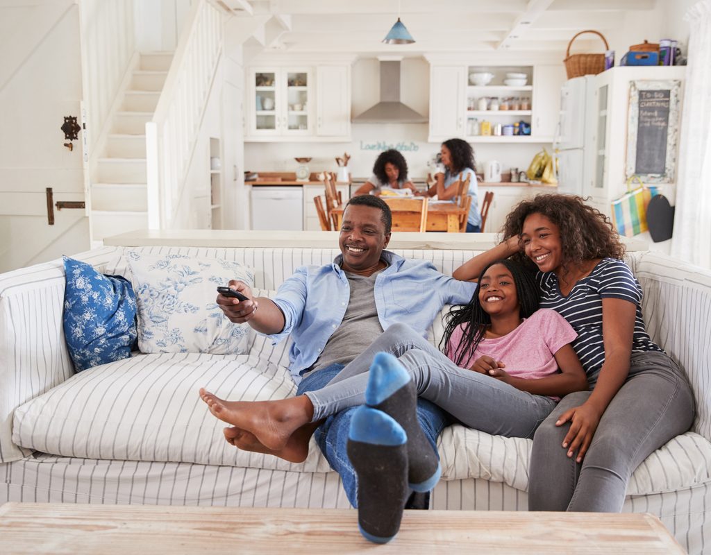 Parents watching TV with teen daughter