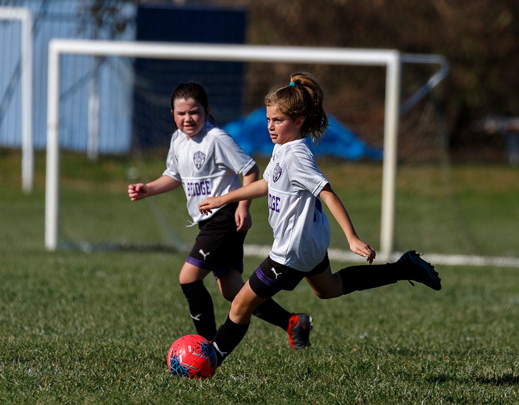Two girls having fun playing travel soccer