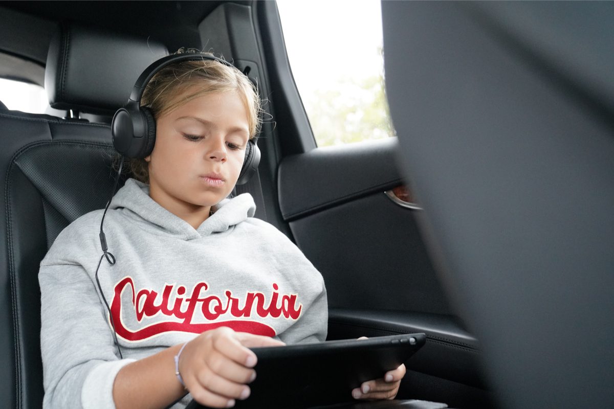 Tween girl watching a movie in a car