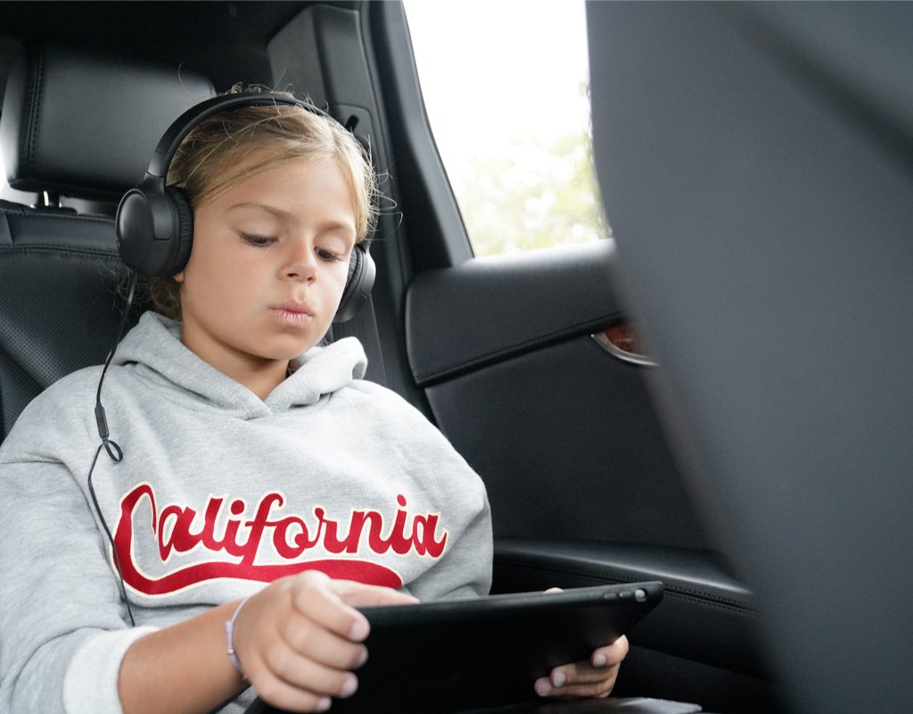 Tween girl watching a movie in a car