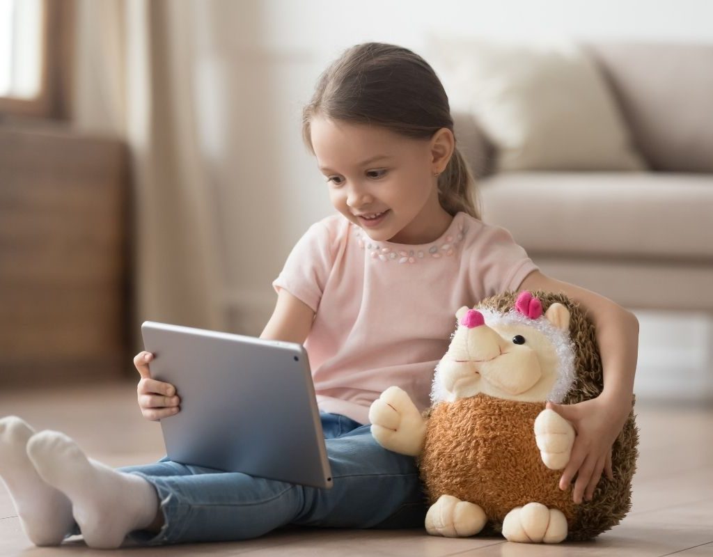 Little girl using her laptop on the floor