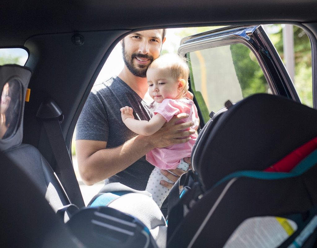 dad putting baby in rear-facing car seat