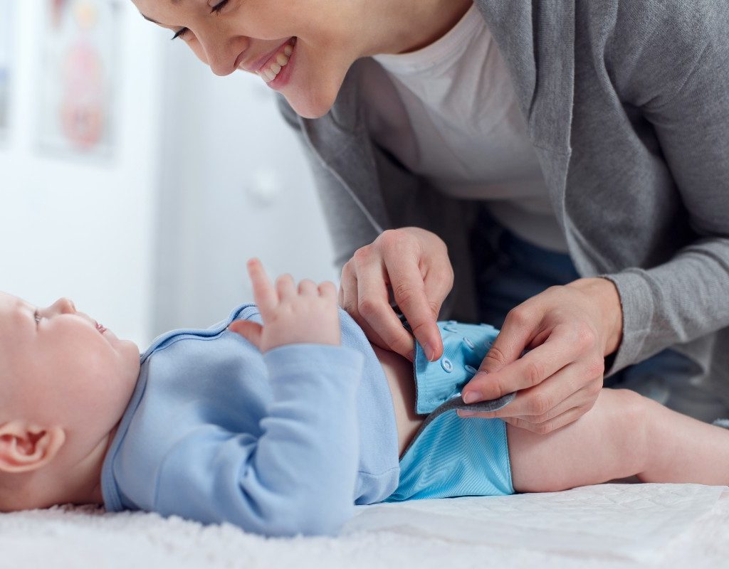 A mom making a cloth diaper change on a baby
