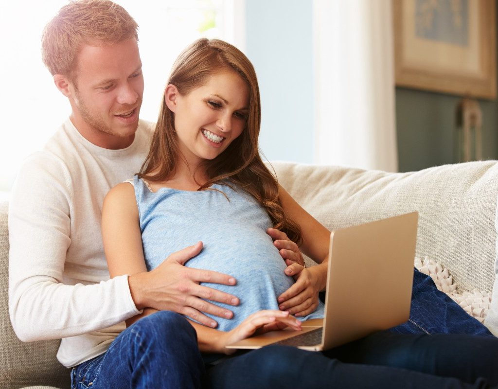 Expecting mom and dad on computer.