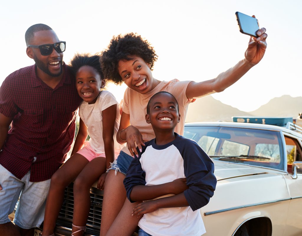Family posing for a selfie on a road trip