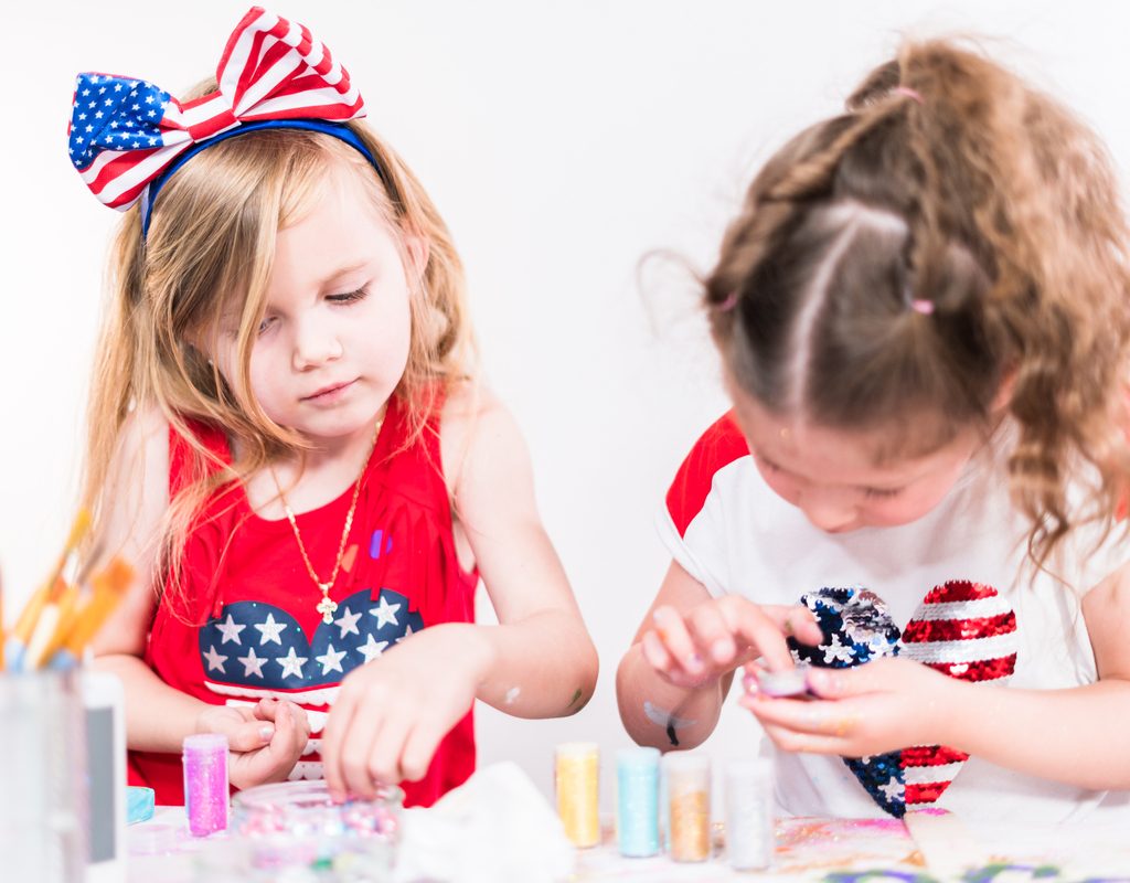 Two little girls making July Fourth crafts