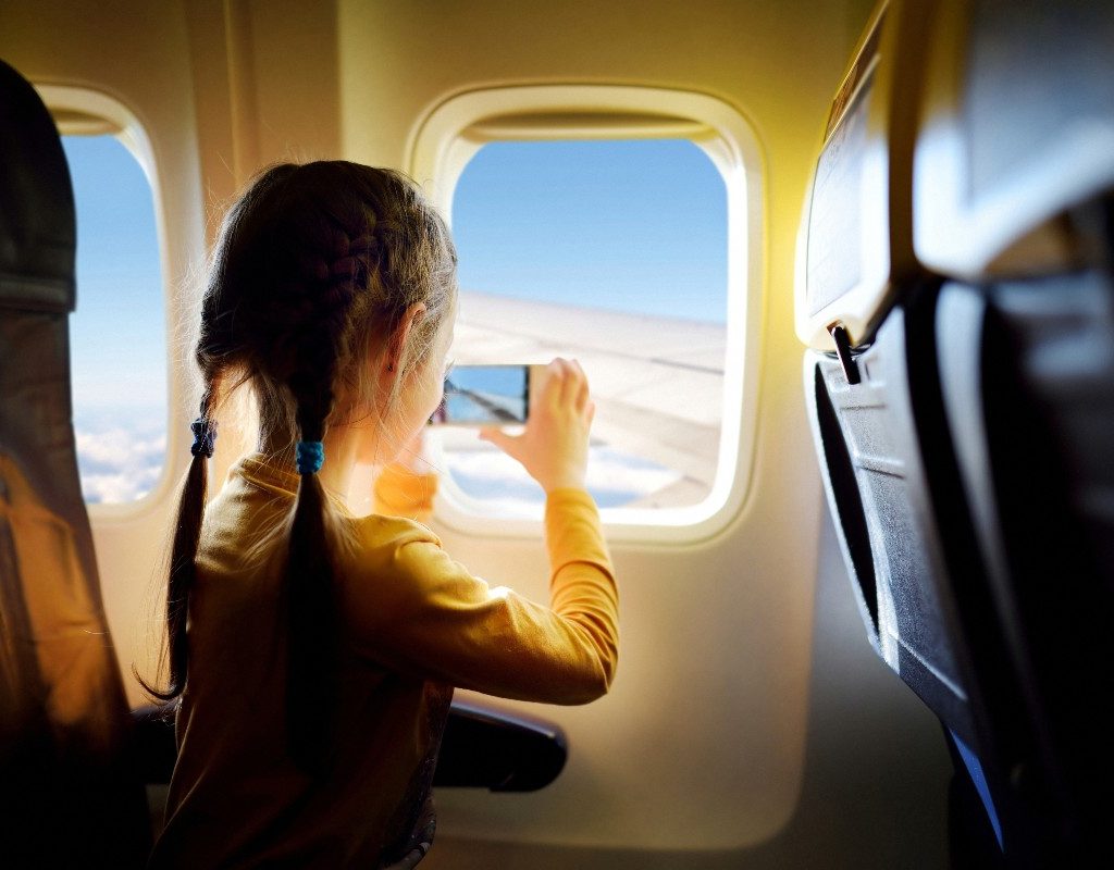 girl taking photo on flight