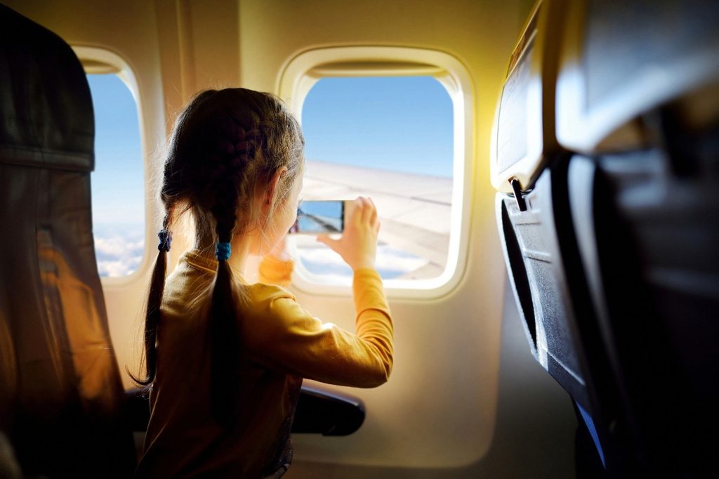 Girl taking photo on airplane flight