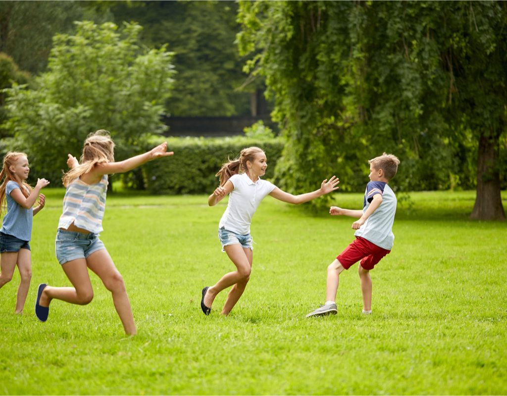 Kids having fun playing tag in the park