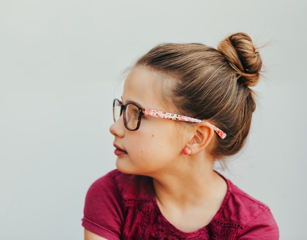 Young girl with glasses and hair bun