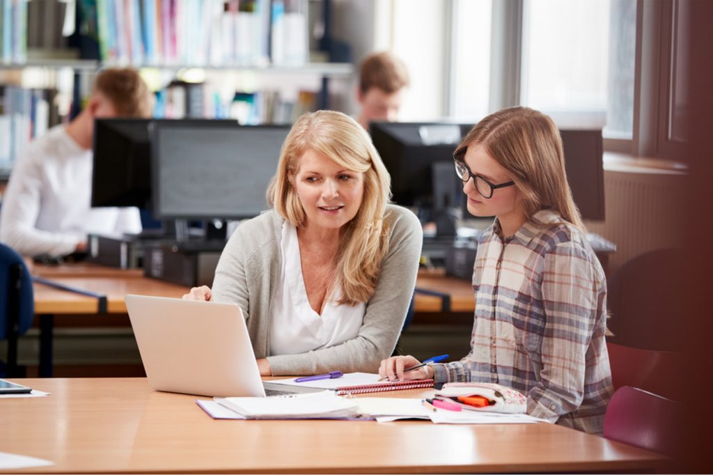 Woman tutoring a middle school student in the library