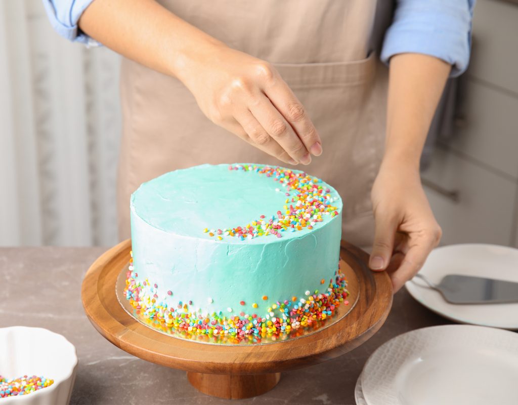 Decorating cake with sprinkles