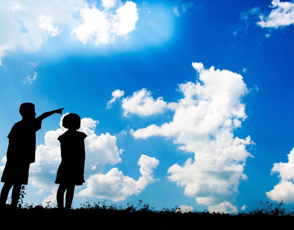 two kids looking up at cloud shapes