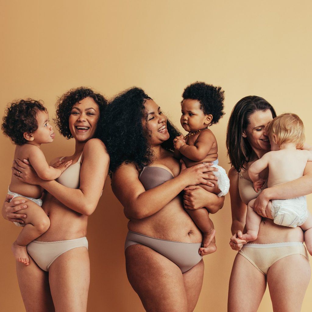 Three women standing together with their babies